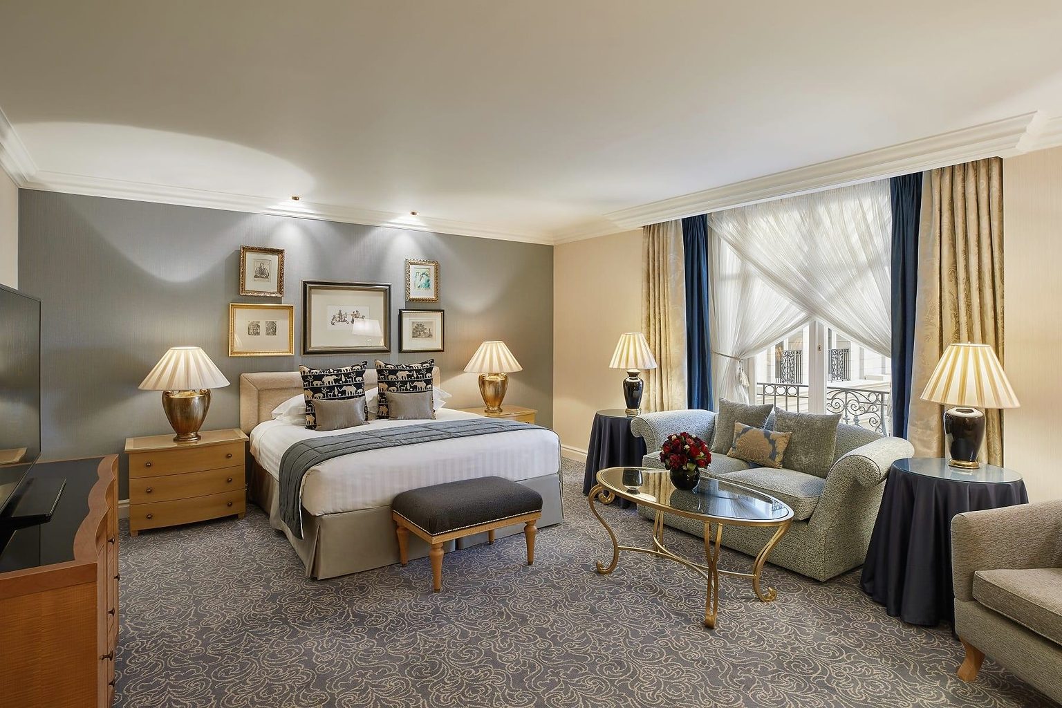Junior Suite with a king bed, a separate sofa seating area and a balcony window