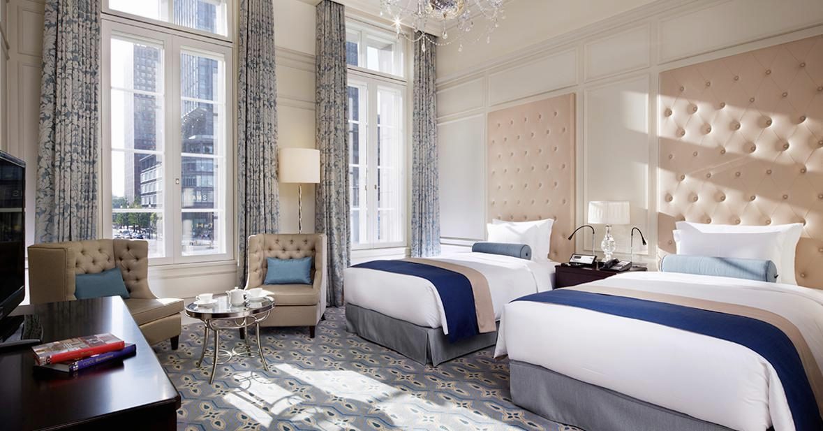 Luxury Twin with two beds, tall windows, wing armchairs and a chandelier